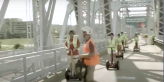Photo of segways crossing a bridge